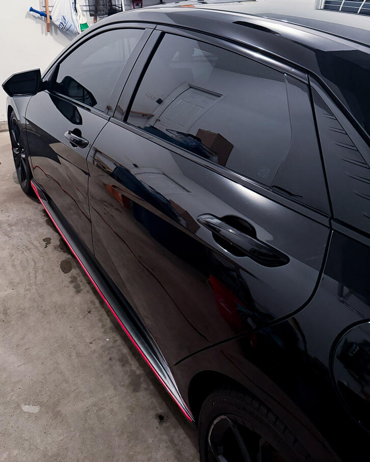 Side profile reflection of a clean black car clear coat following full paint decontamination in Schuylkill Township PA.