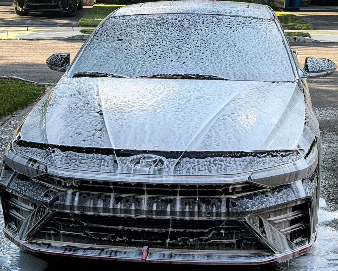 Grey sedan car dwelling in deep cleaning car soap foam during an exterior wash process in Audobon PA.